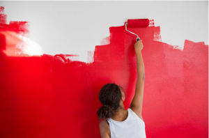 femme peignant un mur en rouge