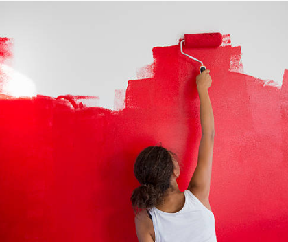 femme peignant un mur en rouge